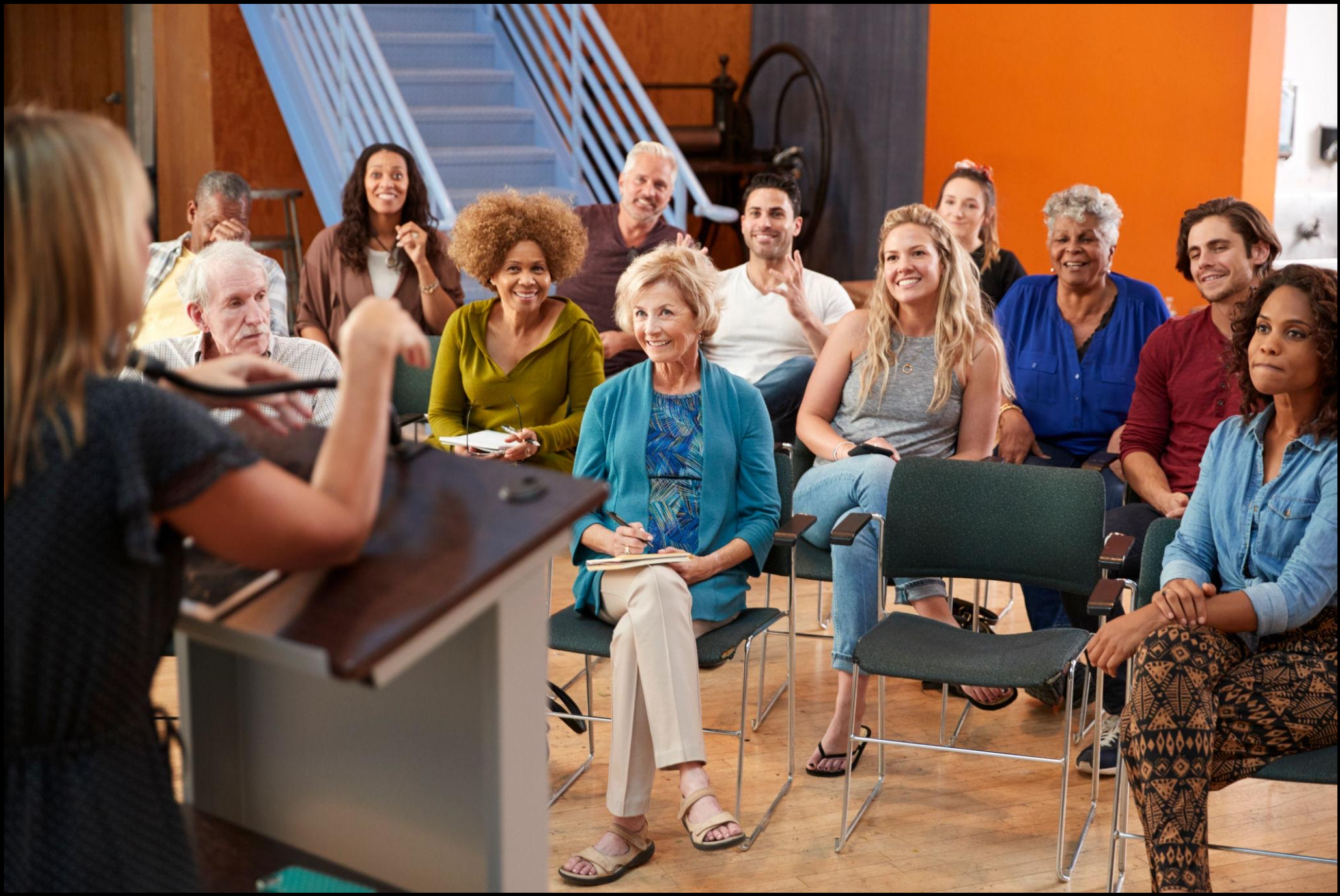 An instructor teaching adults in a classroom during a workshop.